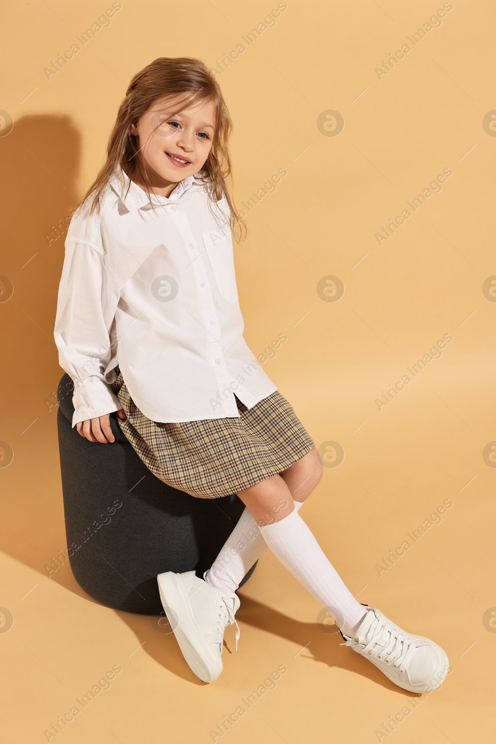 Photo of Fashion concept. Stylish girl on pale orange background