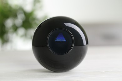 Photo of Magic eight ball with prediction Absolutely on light table, closeup