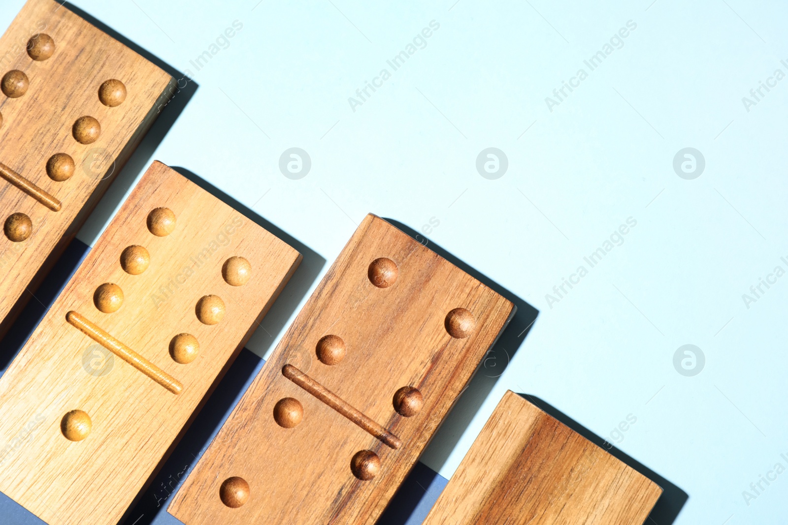 Photo of Wooden domino tiles on color background, flat lay. Space for text