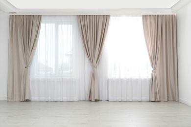 Windows with elegant curtains in empty room