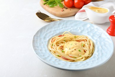 Photo of Delicious spaghetti with meat and cheese sauce on light grey table, space for text