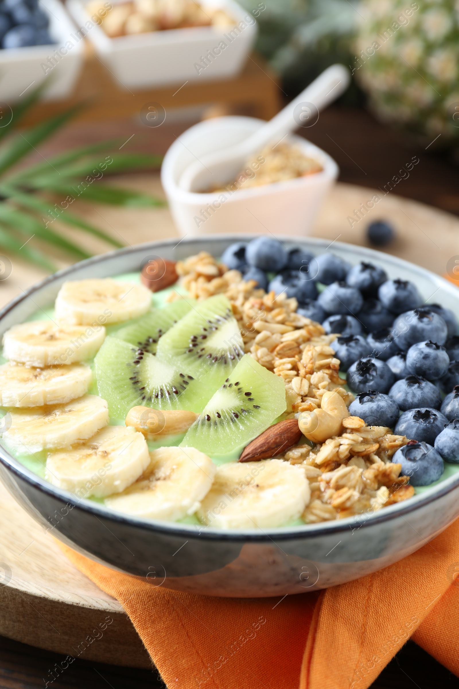 Photo of Tasty smoothie bowl with fresh fruits and oatmeal on table