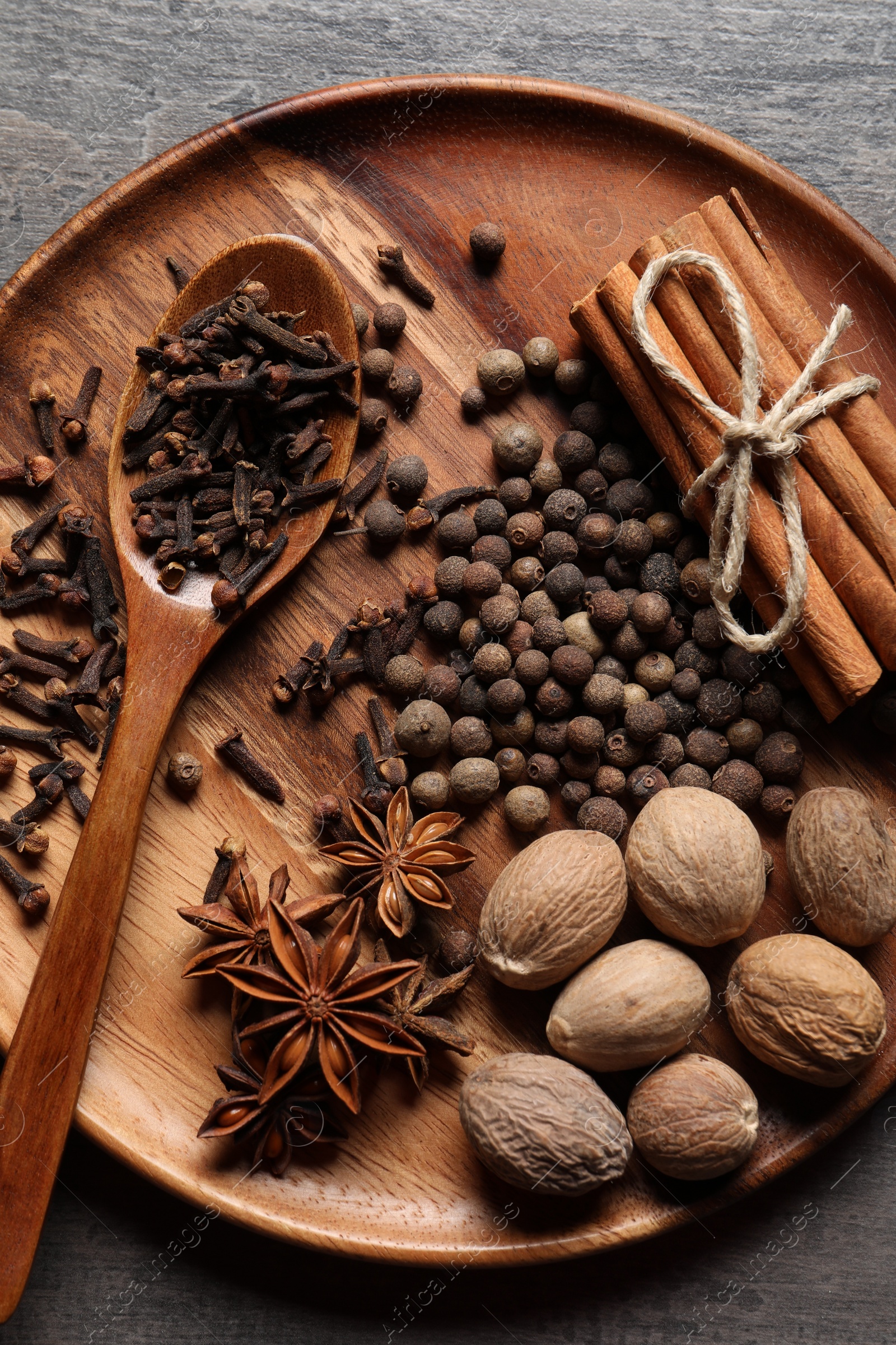 Photo of Different spices and nuts on gray table, top view