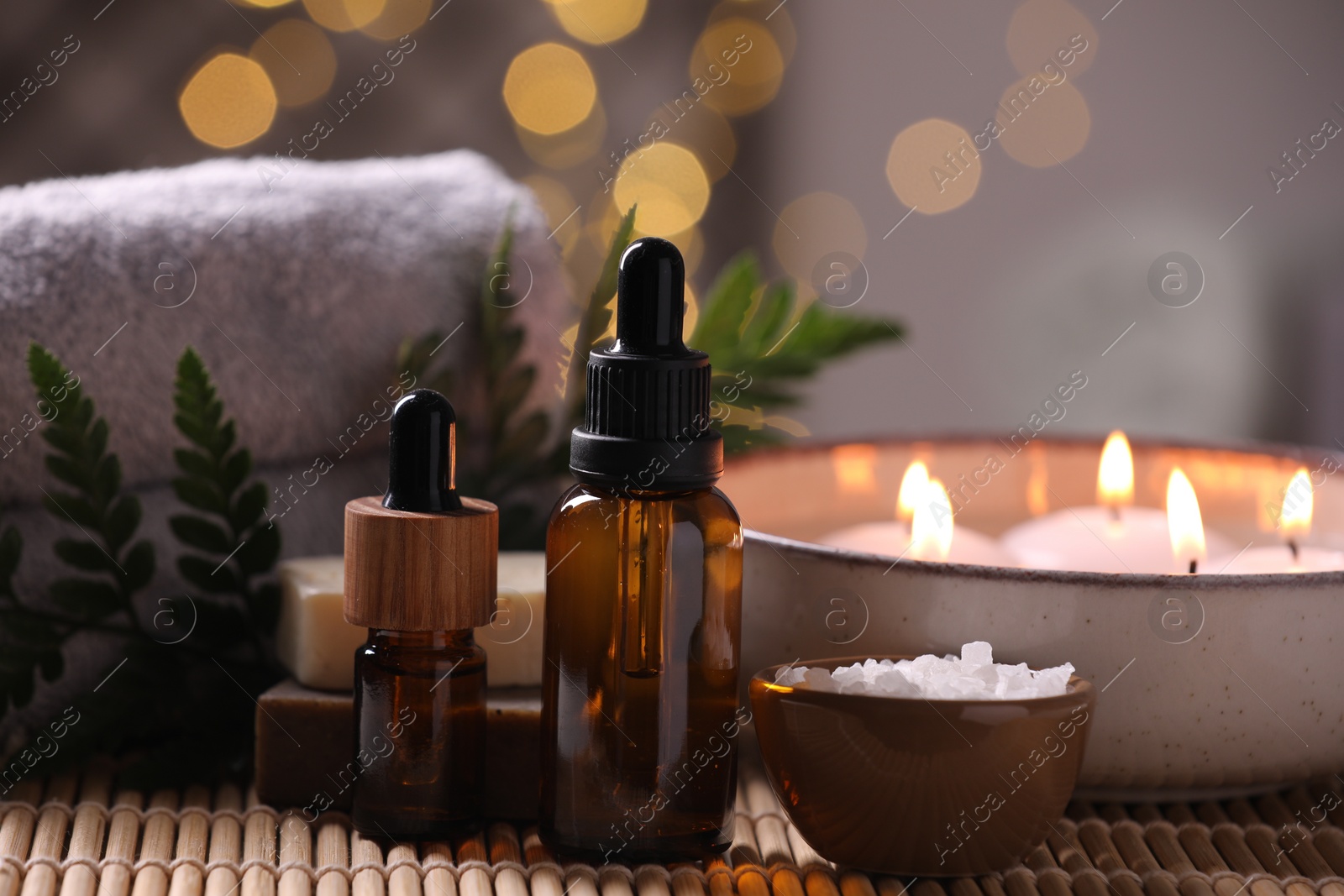 Photo of Beautiful composition with different spa products on table against blurred lights, closeup