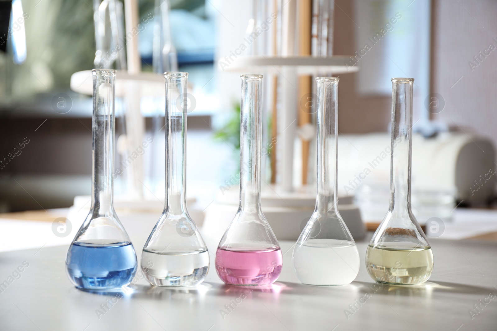 Photo of Glassware with colorful liquids on table indoors. Laboratory analysis