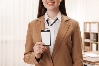 Photo of Woman with blank badge indoors, closeup view