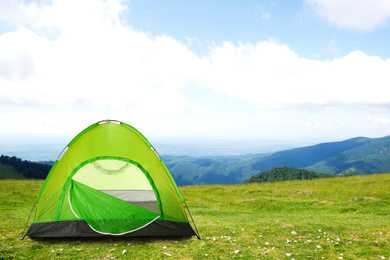 Image of Green camping tent in mountains on sunny day