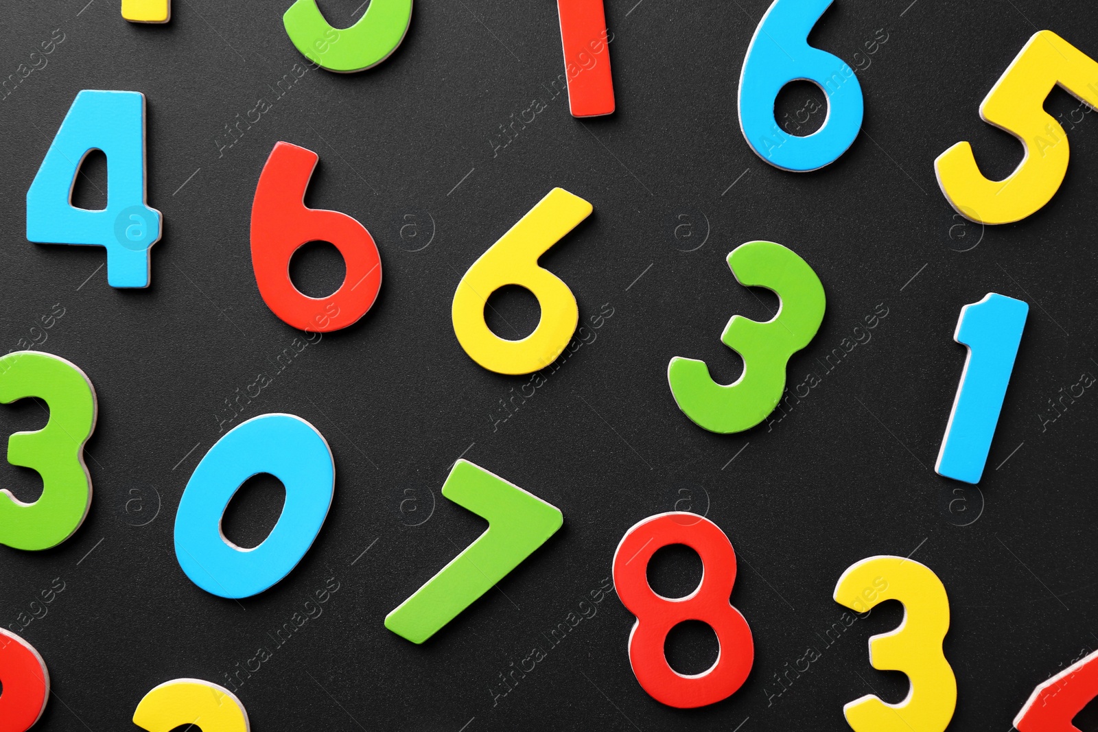 Photo of Colorful numbers on black background, flat lay