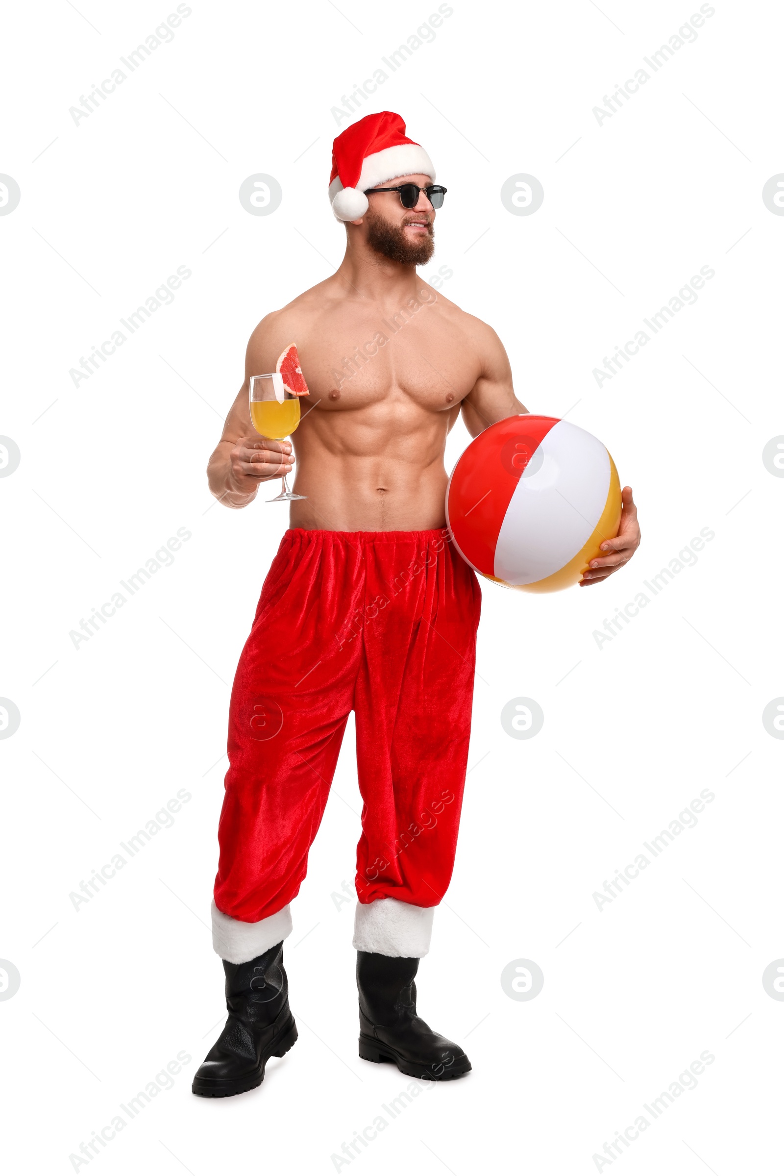 Photo of Muscular young man in Santa hat with ball and cocktail on white background
