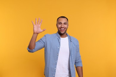 Photo of Man giving high five on yellow background