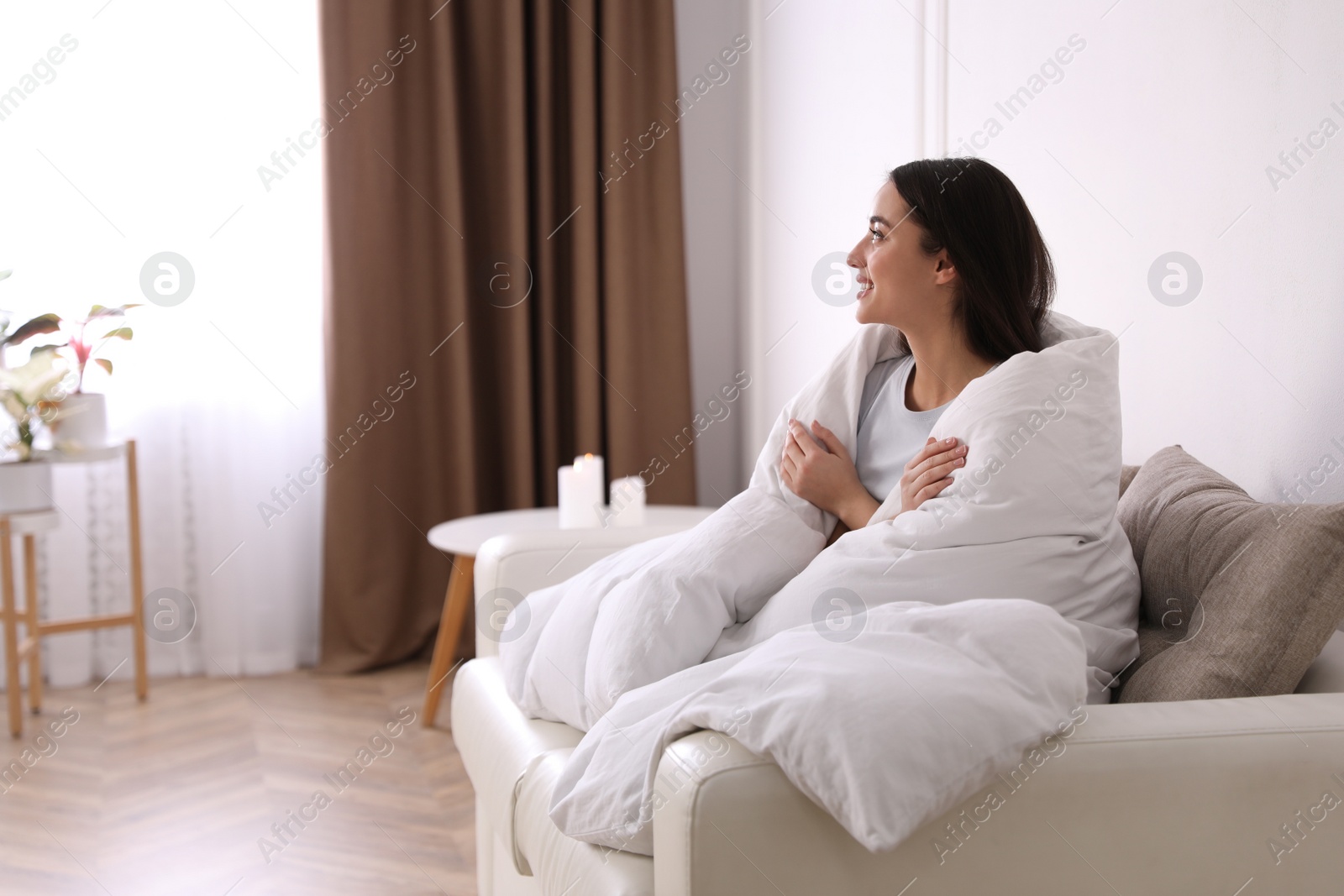 Photo of Woman covered in blanket resting on sofa, space for text