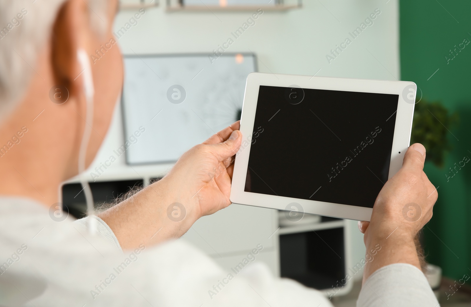 Photo of Man using video chat on tablet at home, closeup. Space for text