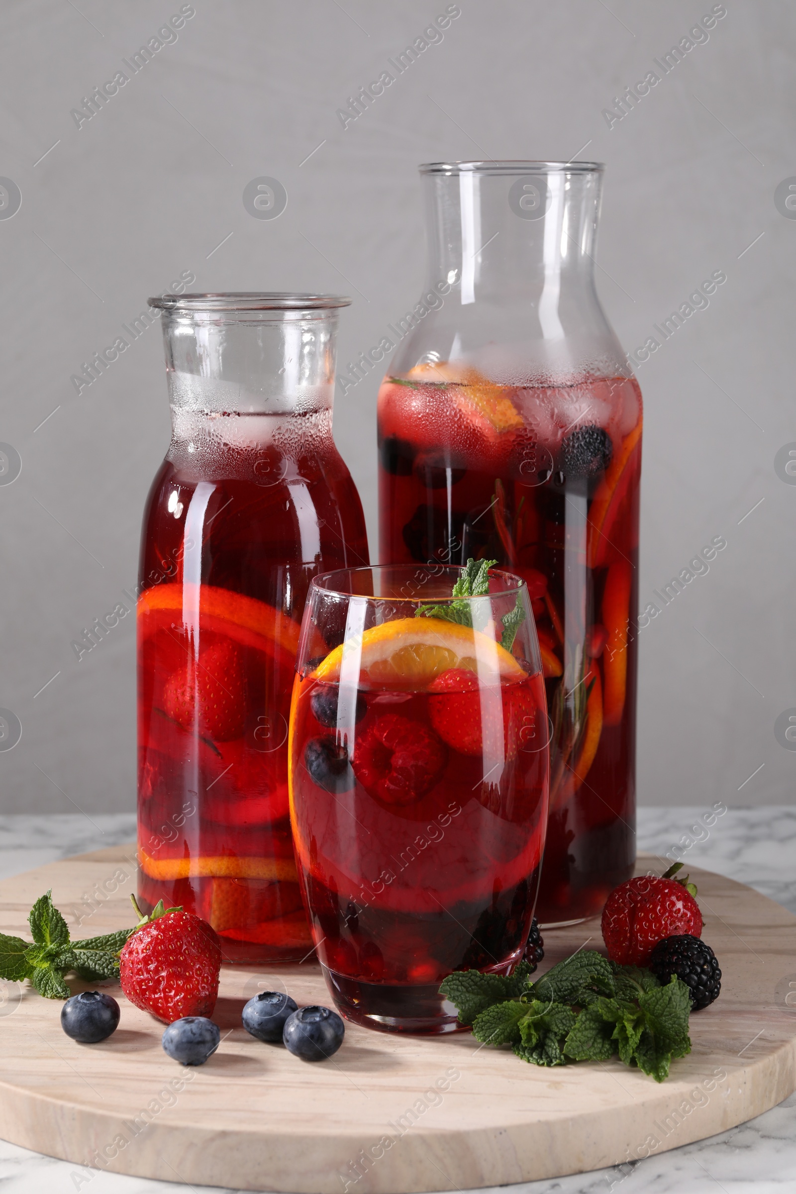 Photo of Delicious refreshing sangria and berries on table