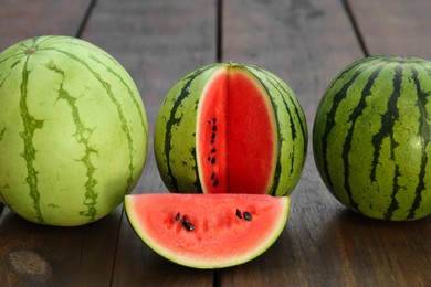 Photo of Different delicious ripe watermelons on wooden table