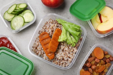 Set of plastic containers with fresh food on light grey table, flat lay