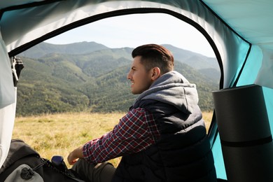 Photo of Man inside of camping tent in mountains