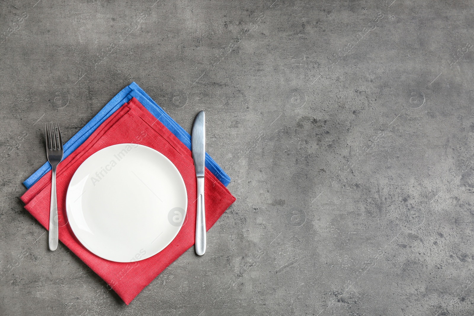 Photo of Patriotic table setting with traditional USA colors on grey background, flat lay. Space for text