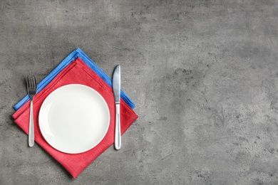 Photo of Patriotic table setting with traditional USA colors on grey background, flat lay. Space for text