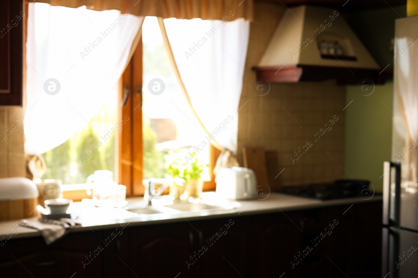 Photo of Blurred view of stylish kitchen interior with sink near window