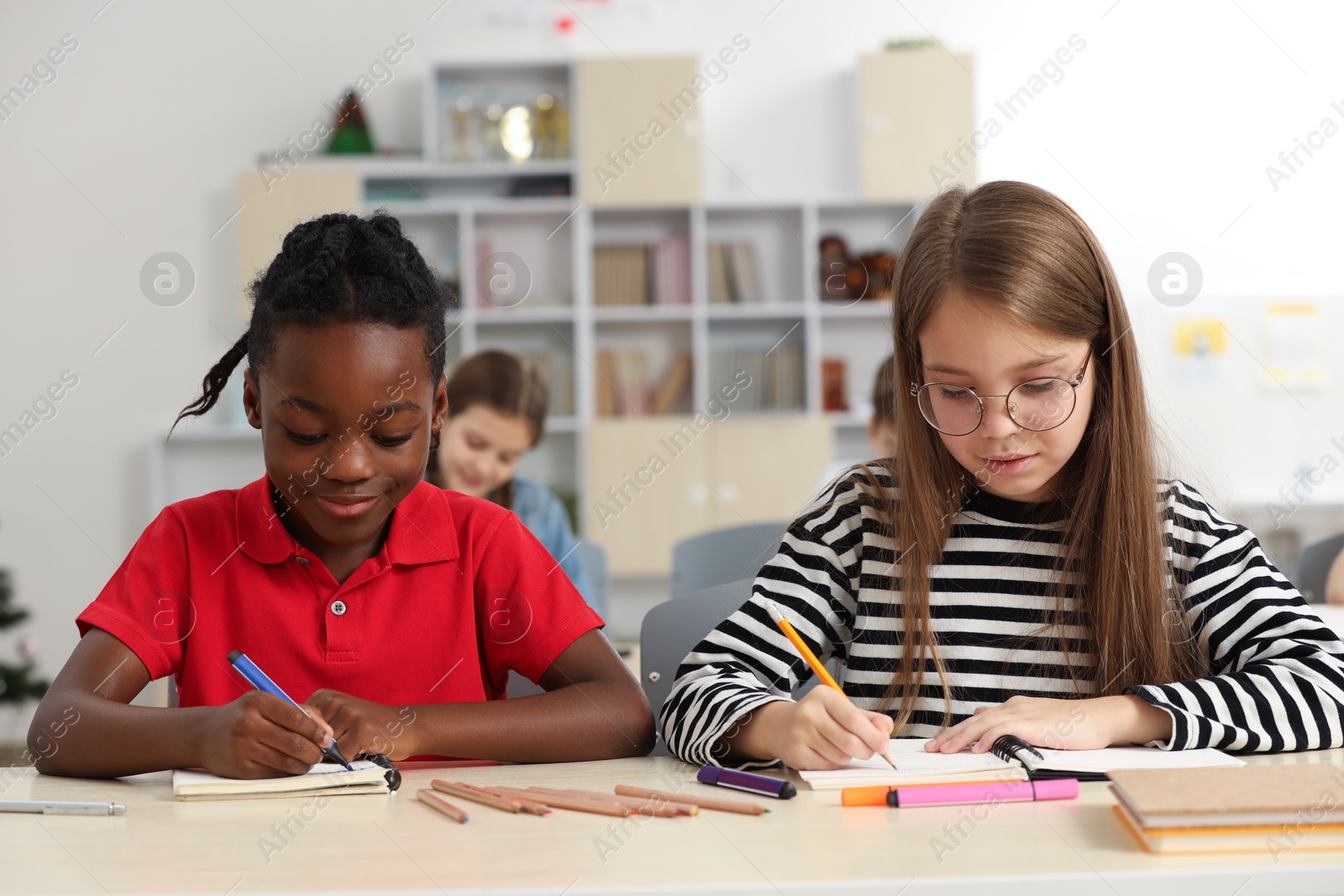 Photo of Cute children studying in classroom at school