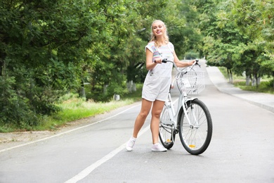 Beautiful woman in casual outfit with bicycle outdoors