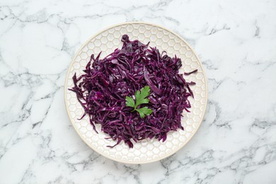 Photo of Tasty red cabbage sauerkraut with parsley on white marble table, top view