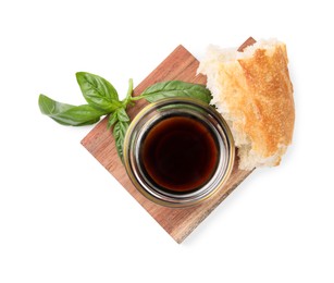 Photo of Bowl of organic balsamic vinegar with oil, basil and bread isolated on white, top view