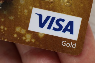 MYKOLAIV, UKRAINE - FEBRUARY 22, 2022: Woman holding Visa credit card, closeup