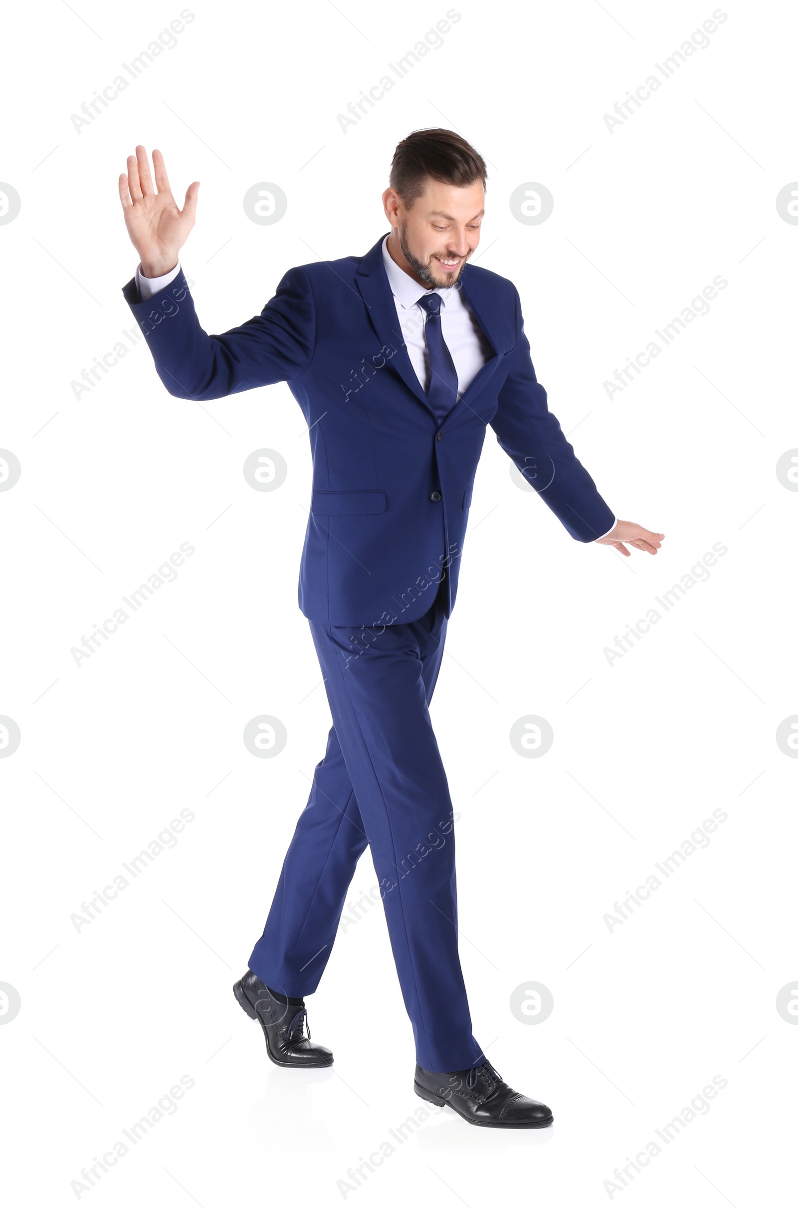 Photo of Full length portrait of businessman balancing on white background