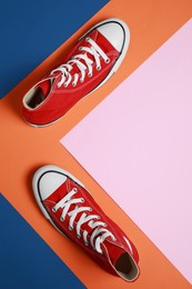 Pair of new stylish red sneakers on colorful background, flat lay