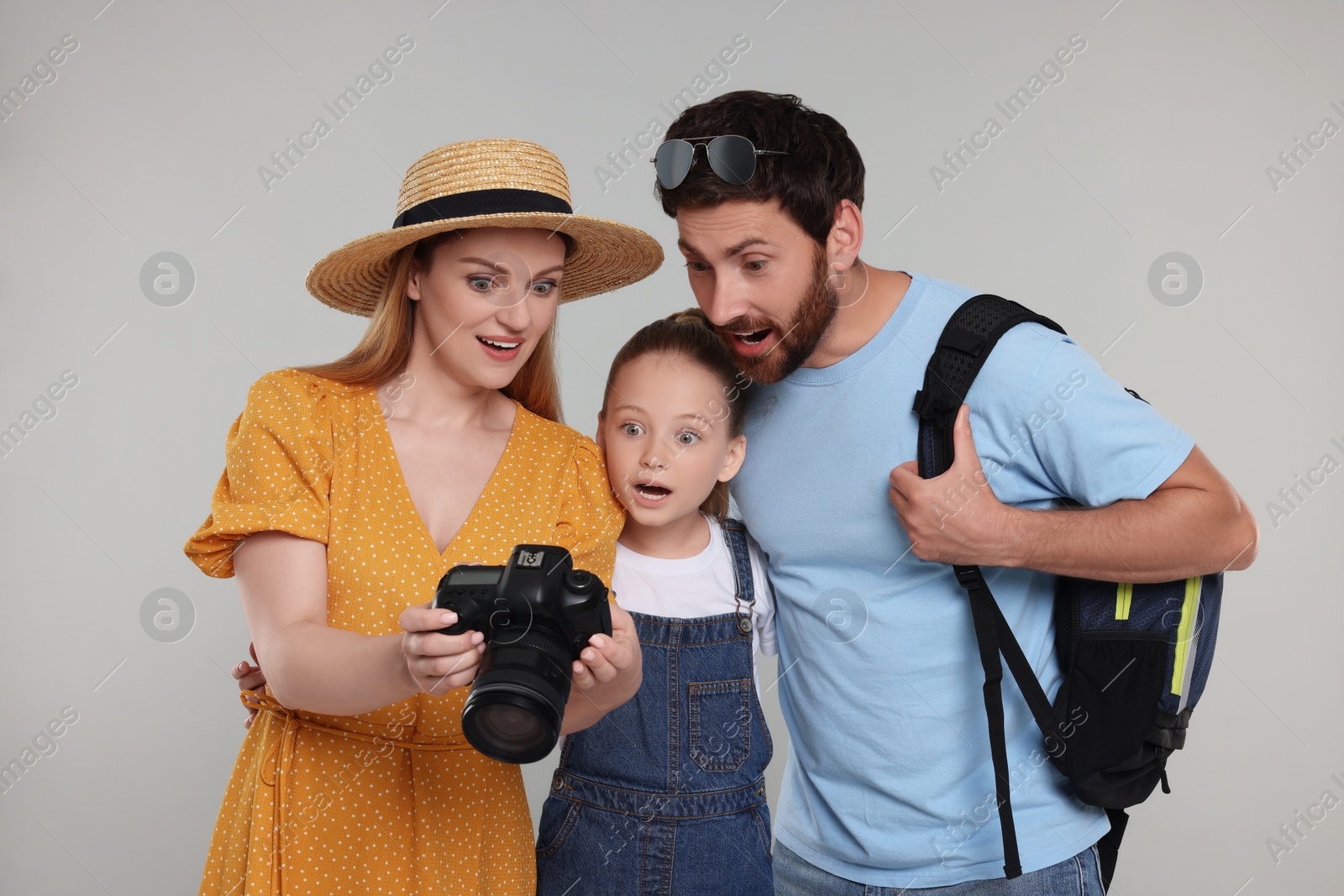 Photo of Surprised family looking into camera on light grey background