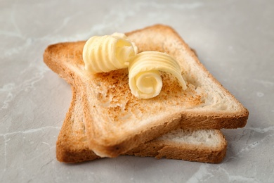 Toasted bread with butter curls on table