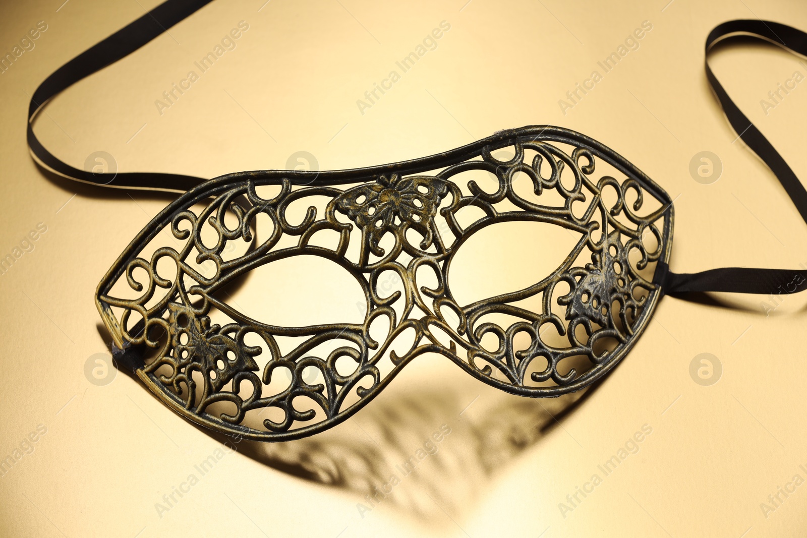 Photo of Elegant face mask on beige background. Theatrical performance