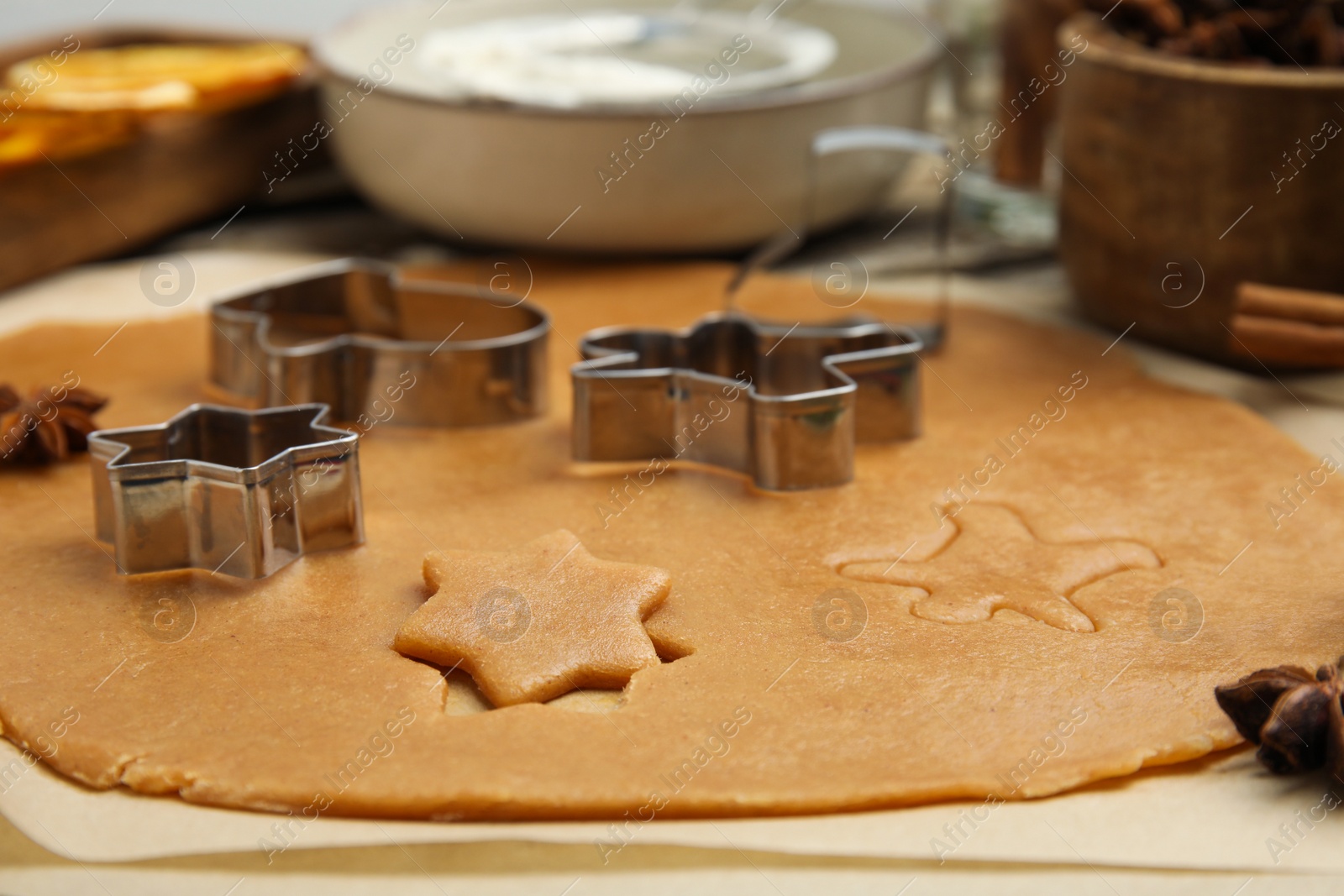 Photo of Dough and cookie cutters on table, closeup