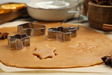 Photo of Dough and cookie cutters on table, closeup