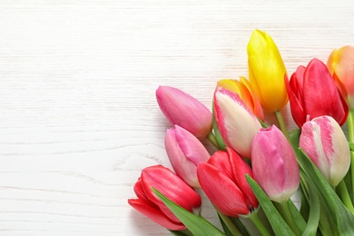 Photo of Beautiful tulips and space for text on wooden background, top view. Spring flowers