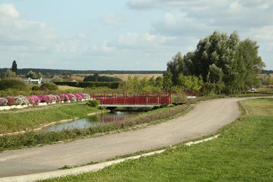 Picturesque view of bridge, river and empty road on sunny day