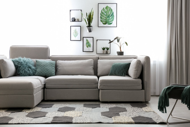 Photo of Comfortable large sofa in light room. Interior design