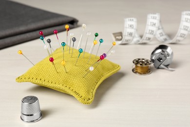 Photo of Pin cushion and thimble on white table