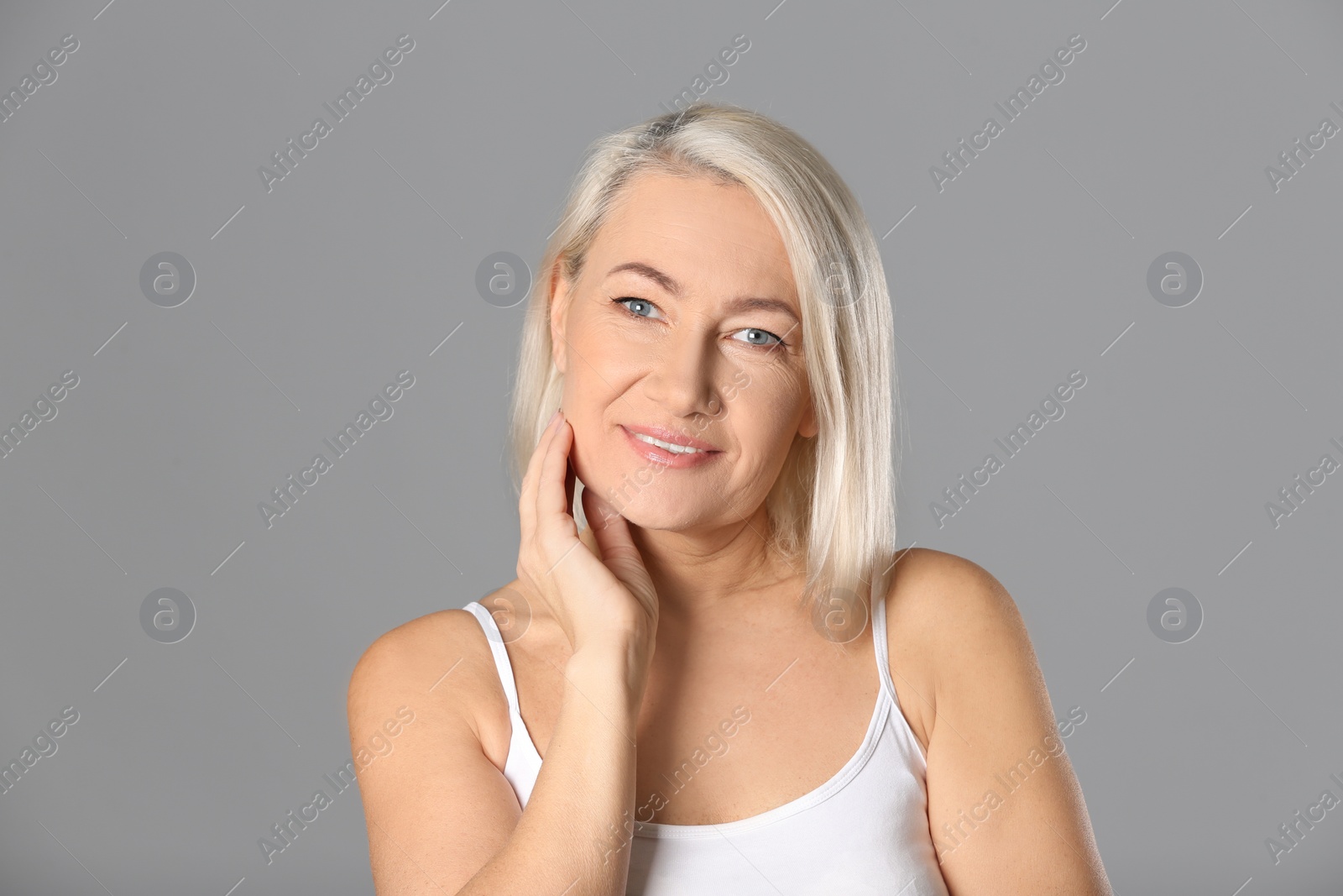 Photo of Portrait of beautiful mature woman on grey background