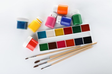 Photo of Paints and brushes for children on white background, top view