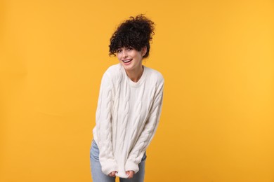 Photo of Happy young woman in stylish white sweater on yellow background