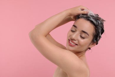 Photo of Beautiful happy woman washing hair on pink background. Space for text