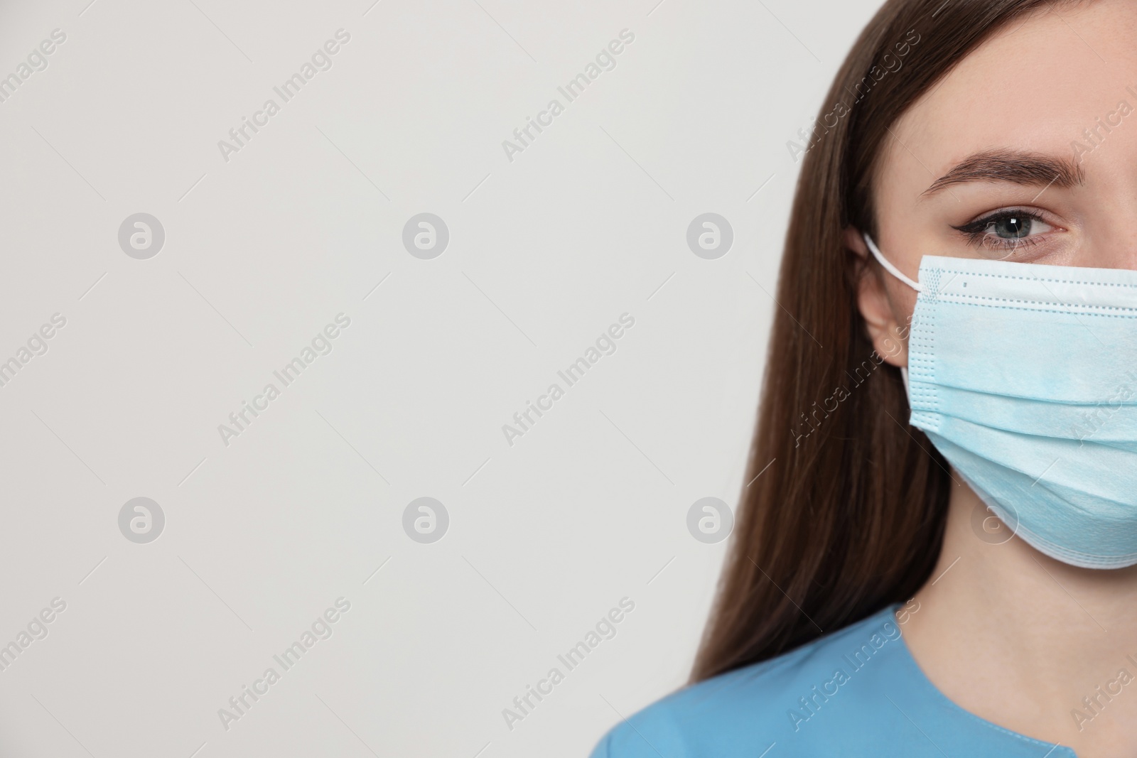 Photo of Nurse with medical mask on white background, closeup. Space for text