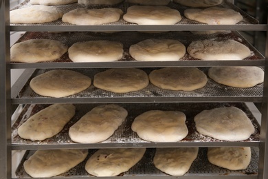 Rack with different unbaked pastries in workshop