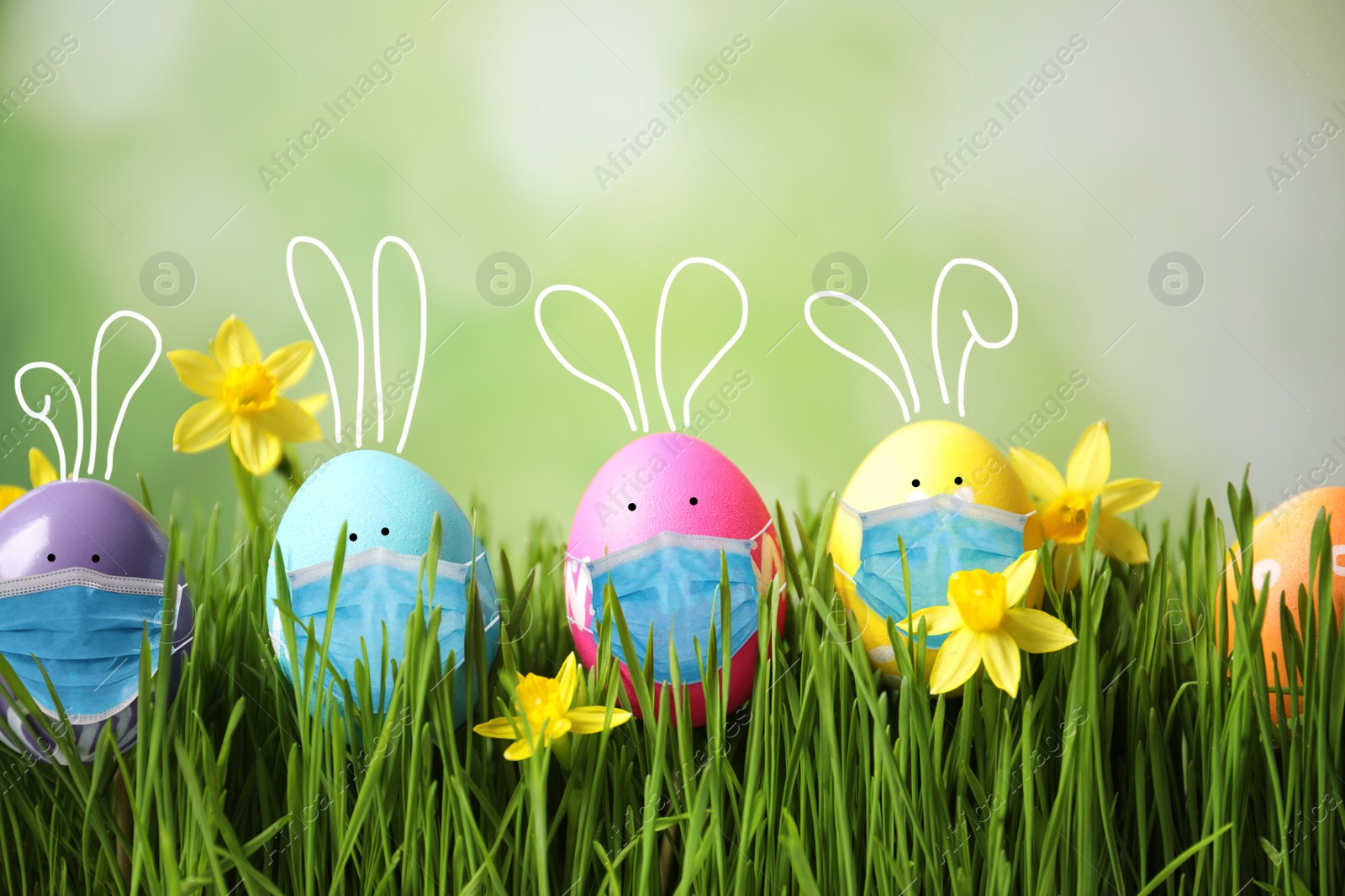 Image of COVID-19 pandemic. Bright Easter eggs with cute bunny ears in protective masks on green grass