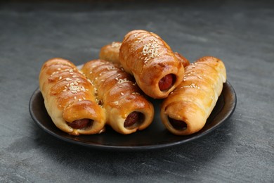 Photo of Plate with delicious sausage rolls on grey table