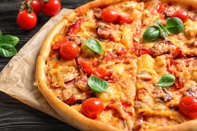 Delicious pizza with tomatoes and sausages on table, closeup