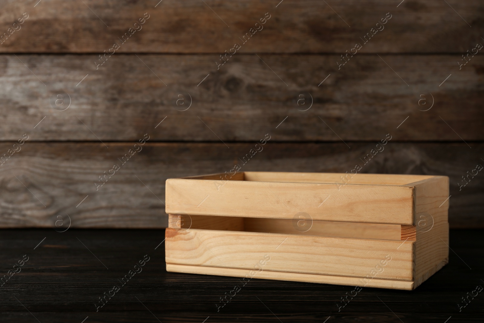 Photo of Empty crate on table against wooden background. Space for text