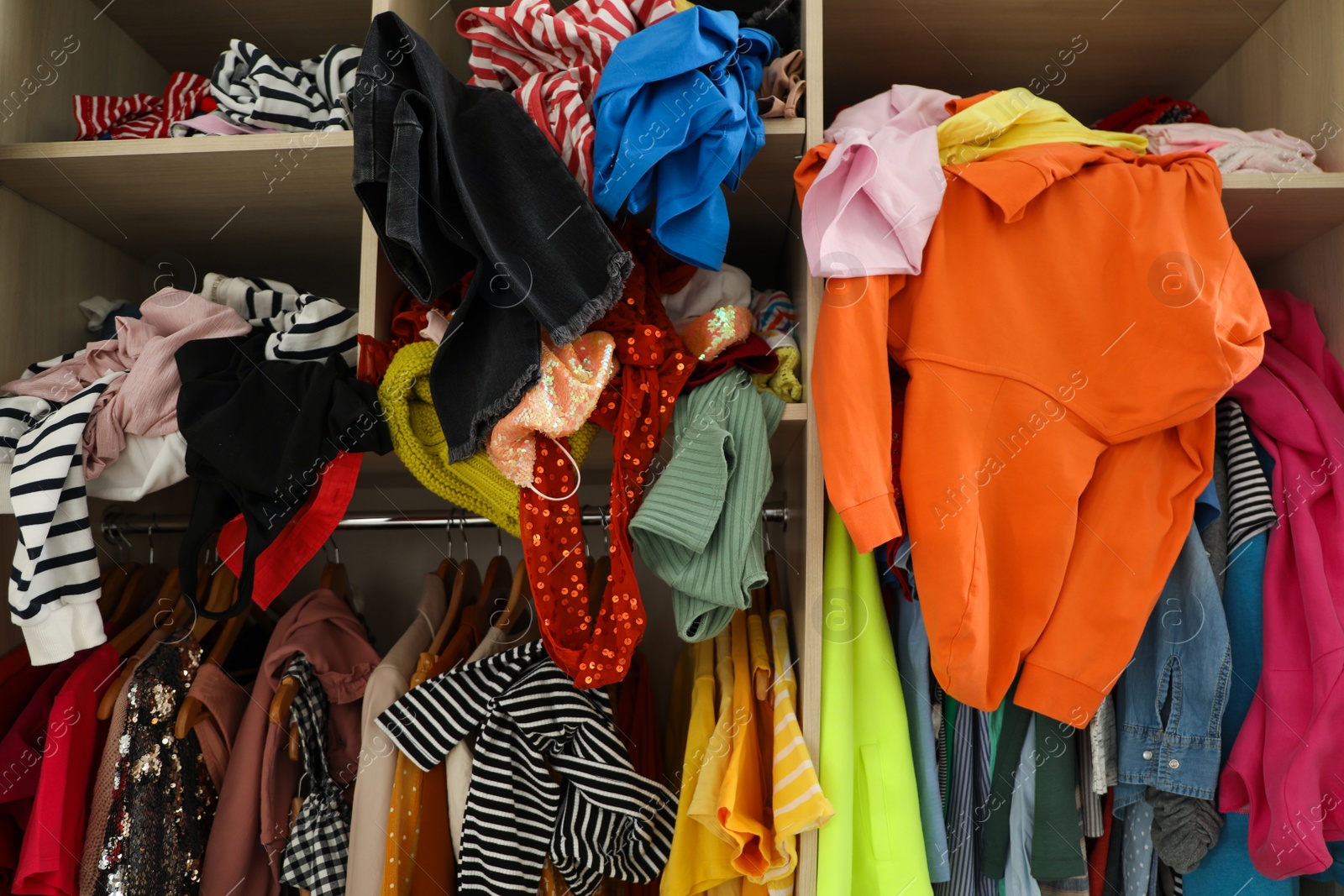 Photo of Messy wardrobe with different clothes. Fast fashion concept